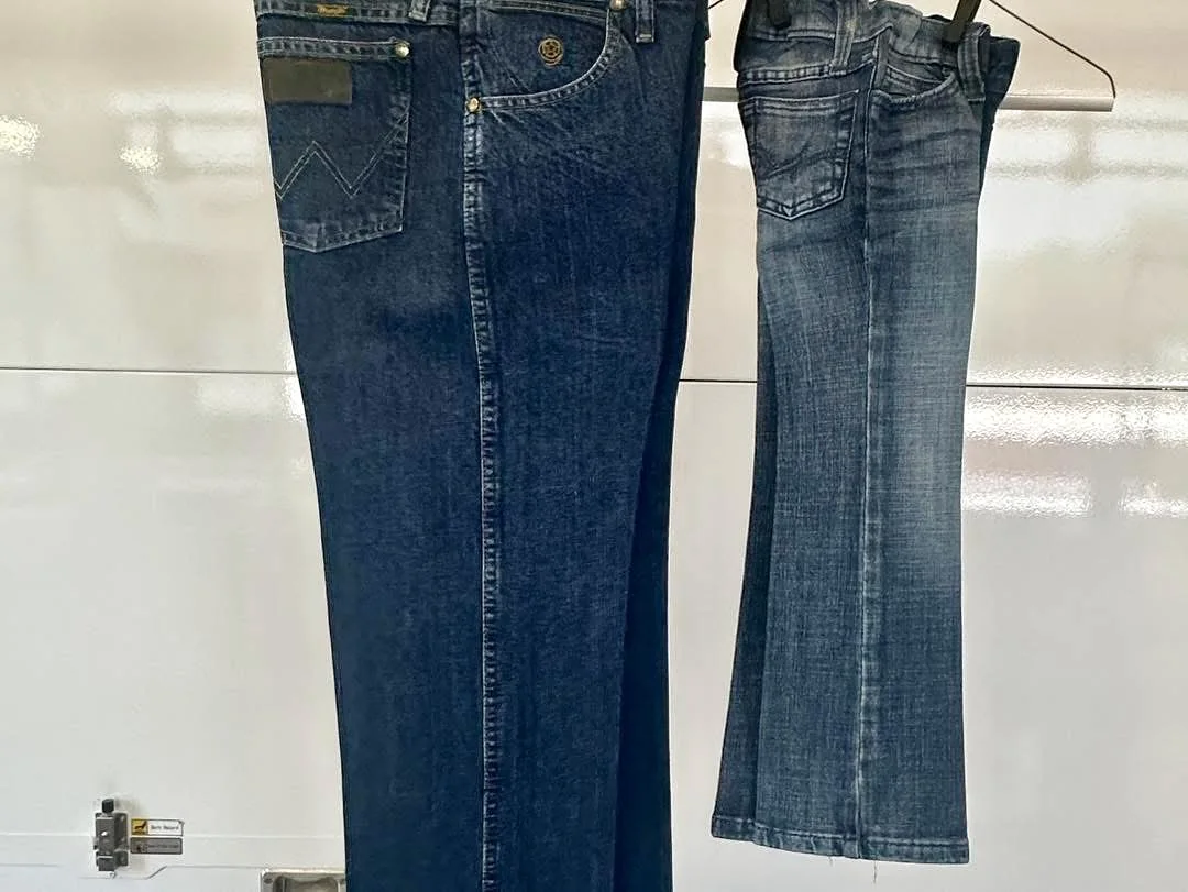 Two pairs of pressed jeans hanging in the shop